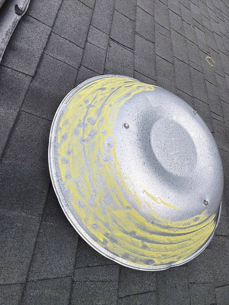 Hail dented roof vent dome highlighted with yellow inspection chalk, HAAG certified inspection Northern VA