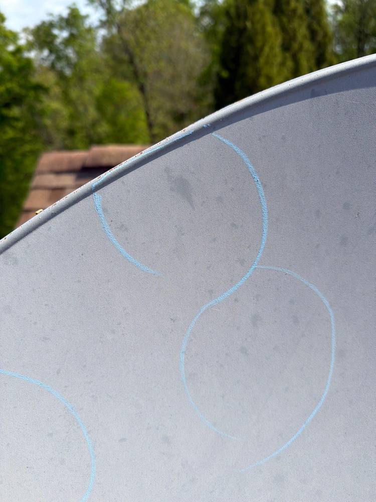 Hail strike marks circled in chalk on satellite dish, storm verification evidence Northern Virginia