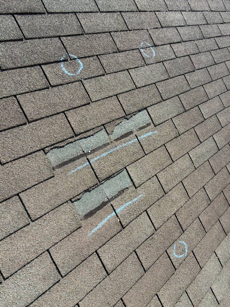 Wind damaged torn shingle tabs with exposed mat marked in chalk, Northern Virginia roof inspection